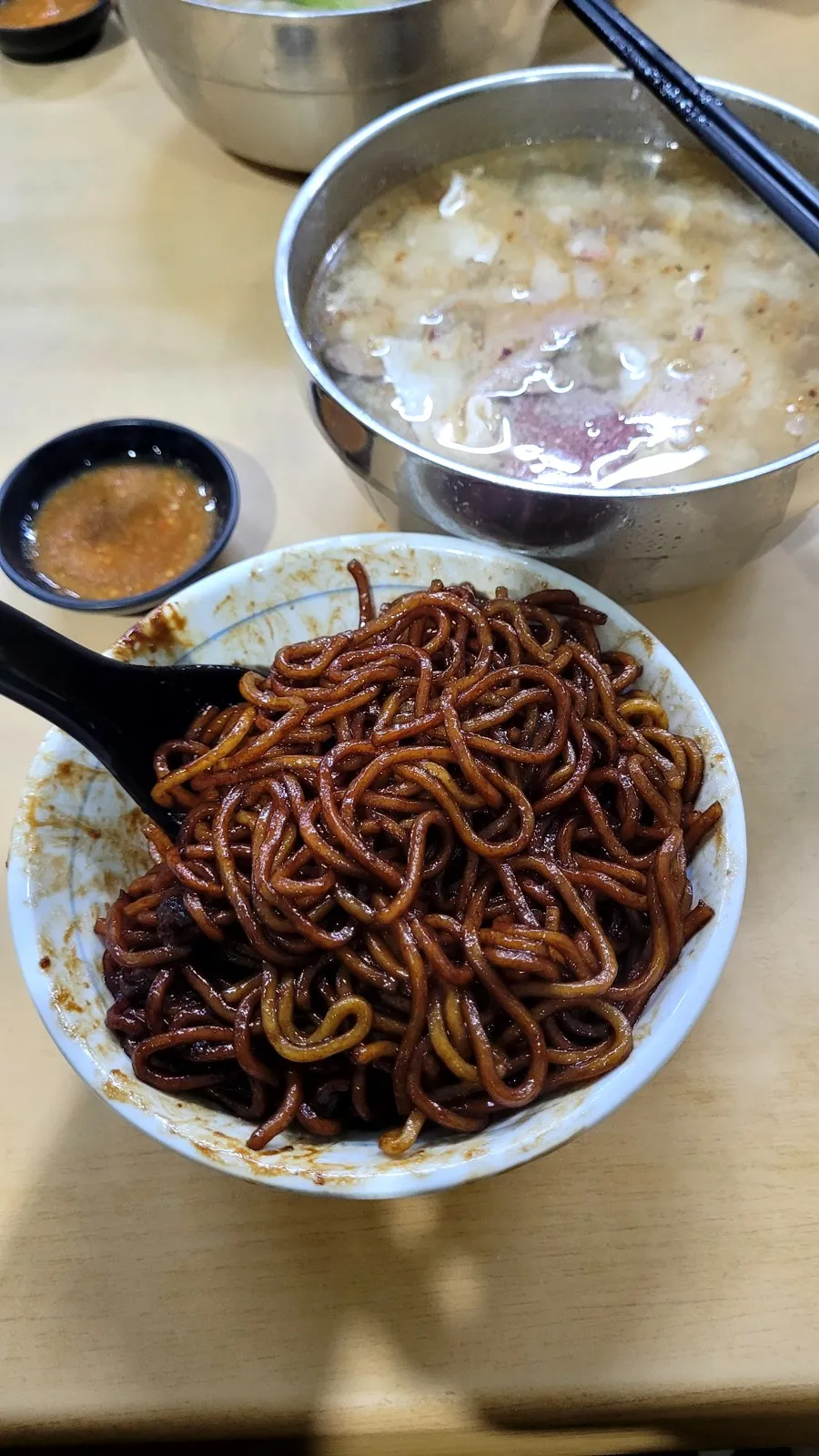 Black fried noodles with a bowl of soup