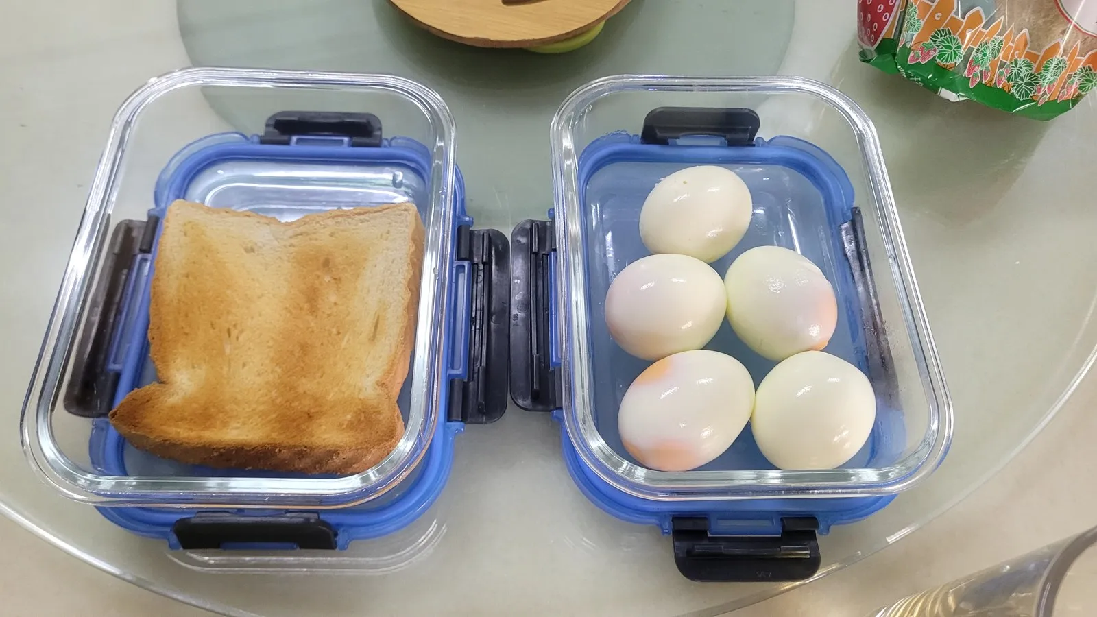 Toast and boiled eggs packed in glass lunch boxes