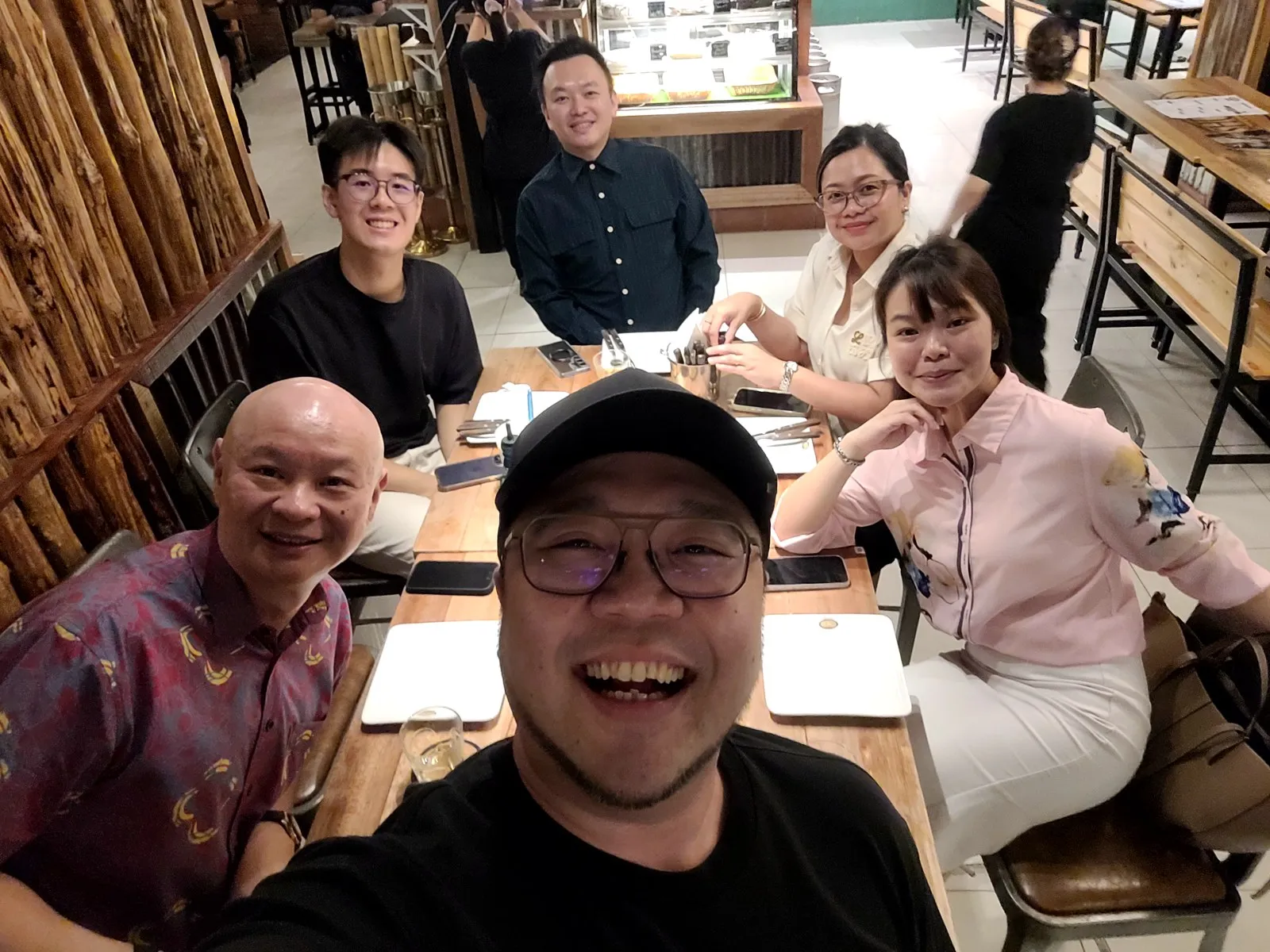 Group selfie with friends at a restaurant table