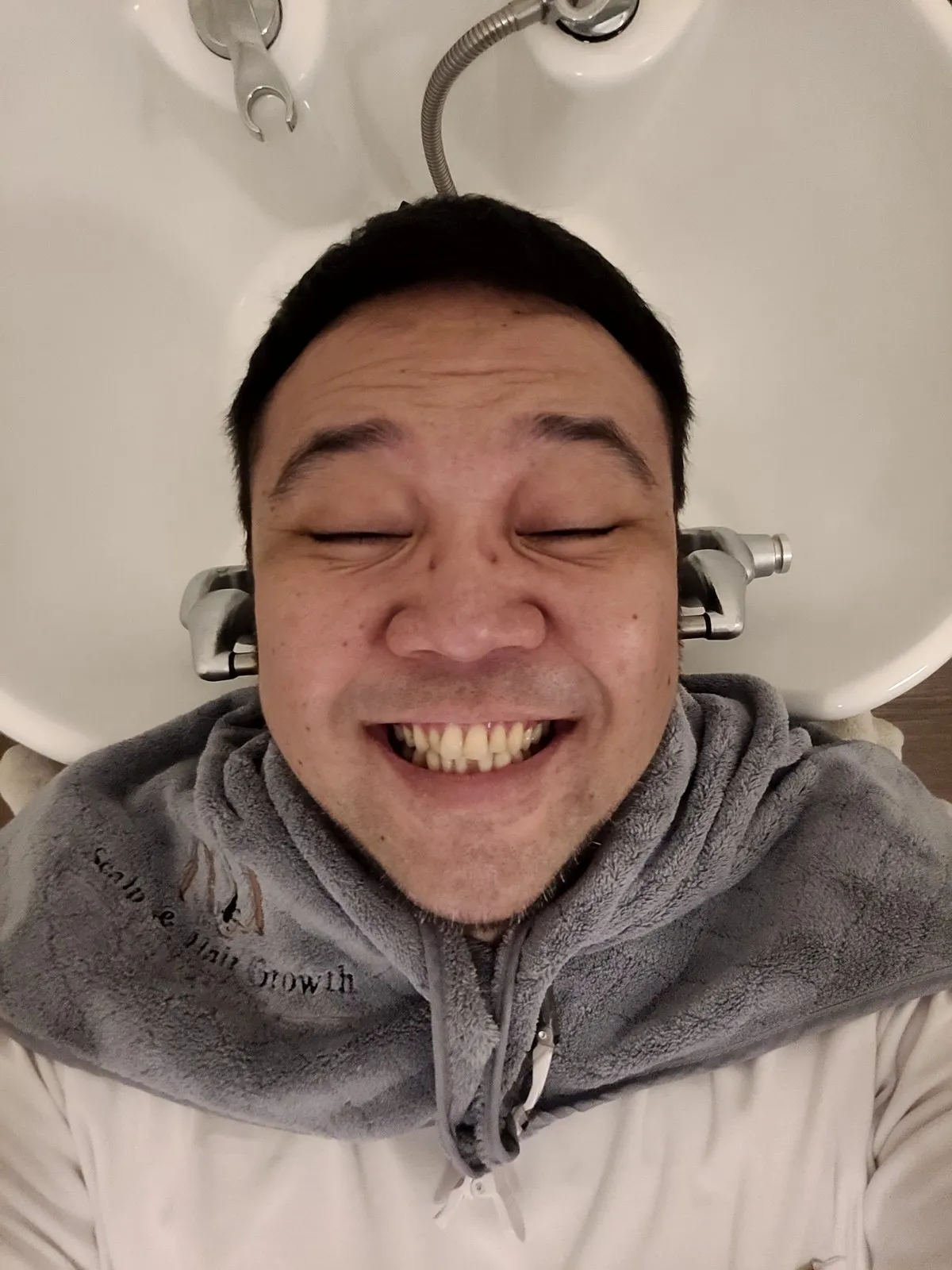 Me with my eyes shut, grinning, at a hair wash
