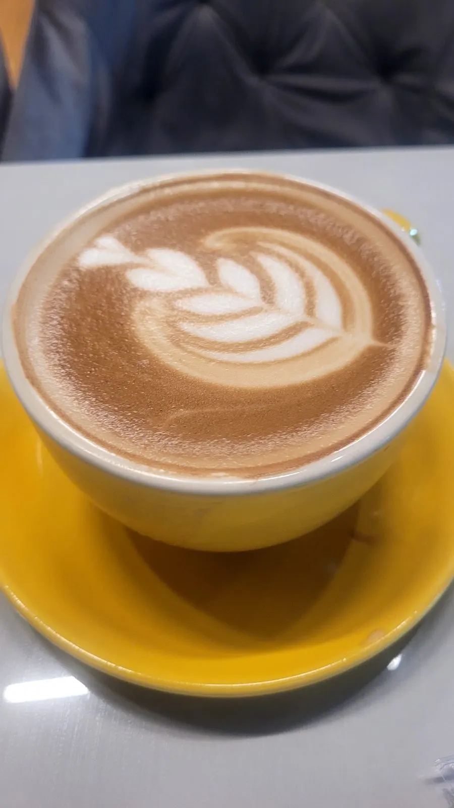 A latte in a yellow cup